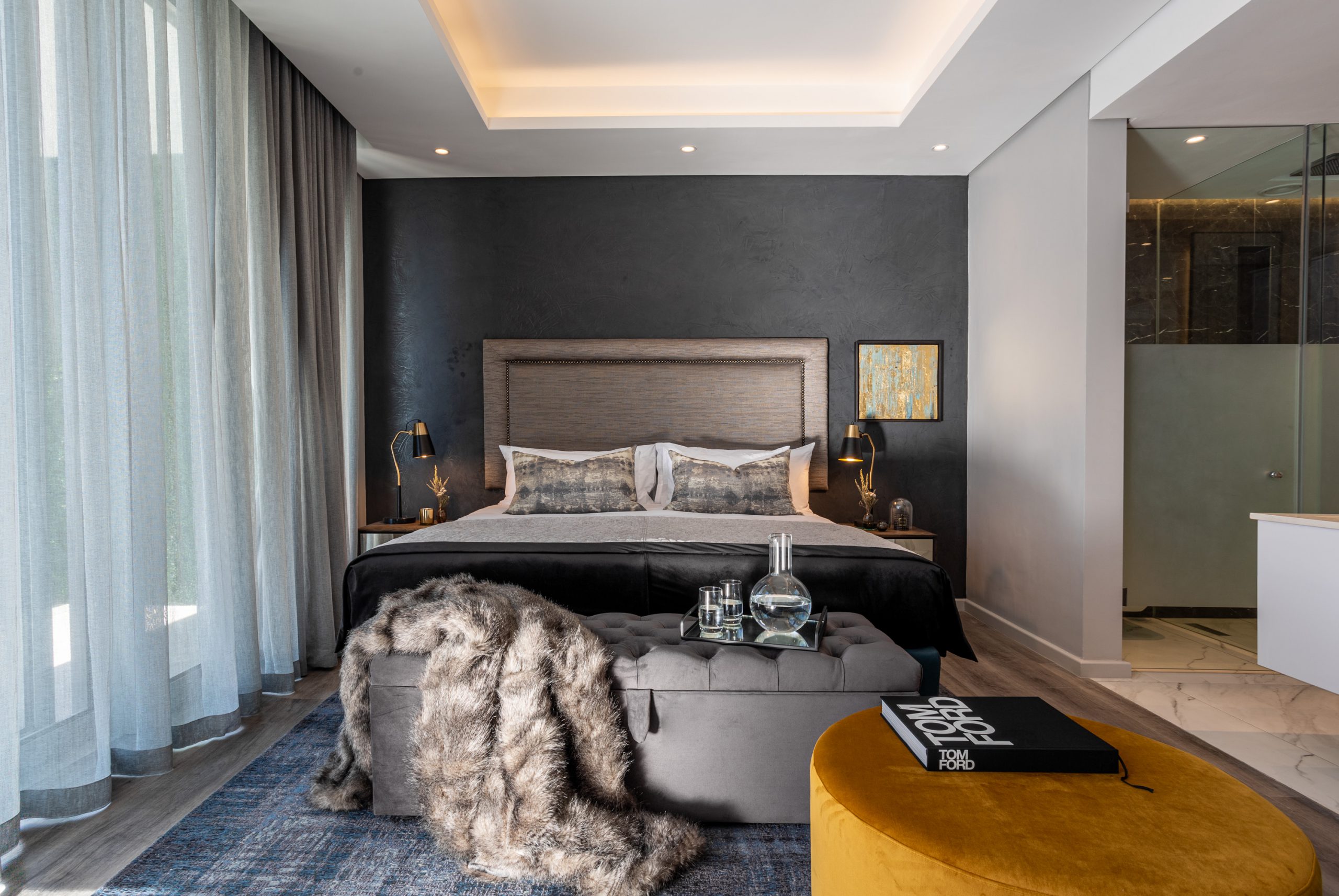A bedroom setting with dark luxurious finishes