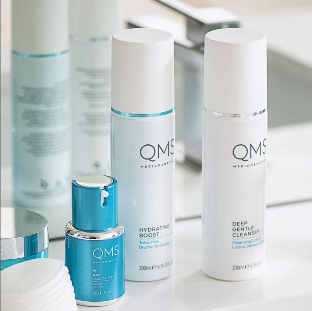 Blue and white bottles of QMS cosmetics displayed on a counter